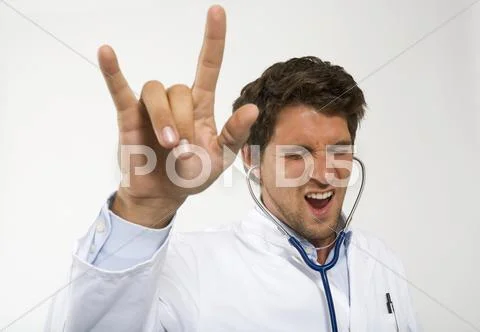 Male doctor dancing with stethoscope in ear, close-up Stock Photos