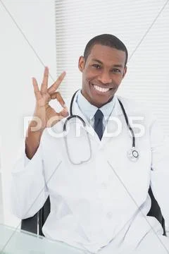 Male doctor gesturing okay sign at medical office Stock Photos