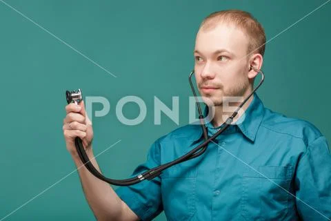 Male doctor with stethoscope smiling on blue background Stock Photos