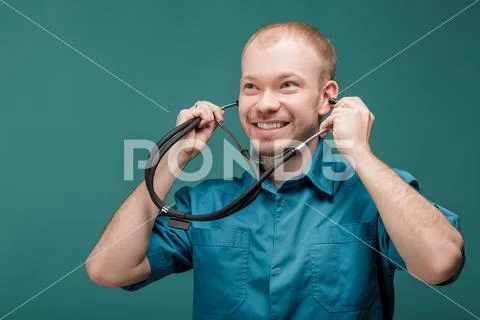Male doctor with stethoscope smiling on blue background Stock Photos
