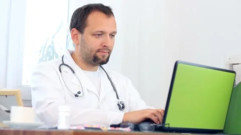 Male doctor working on computer Stockbeeldmateriaal 7758489