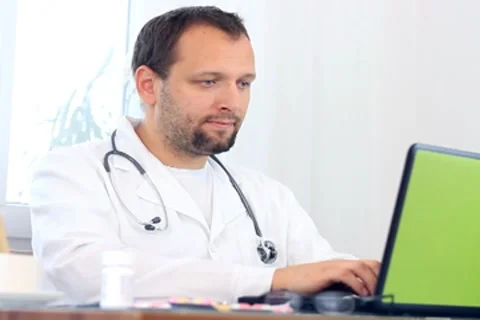 Male doctor working on computer Stockbeeldmateriaal 7758491