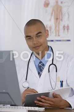 Male Doctor Writing In Notebook
