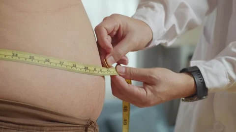 Male Doctor'S Hands Using Tape Measuring Fat Male Patient'S Waist Video stock 249609927
