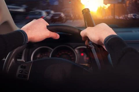 Male driver drinking beer while driving car Stock Photos