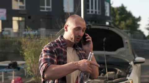 A male driver drinks alcohol while driving and calls emergency services. Stock Footage 250252643