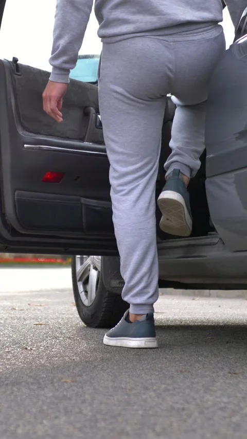 A male driver opens the drivers seat door, gets behind the wheel of a car and Stock Footage 317160891