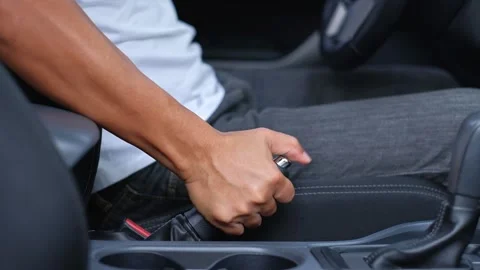 The male driver pulls the handbrake when parking Stock Footage 144993052