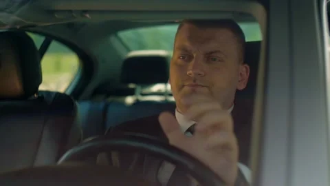 Male driver sits behind the wheel and waits for cars to move  Stock Footage 201086607