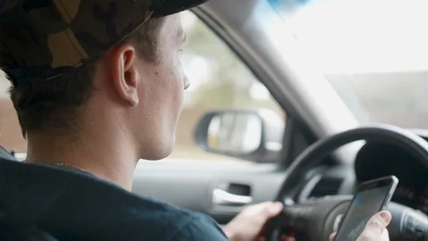 Male driver sitting in the car and holding smartphone with map gps navigation Stockbeeldmateriaal 112738136