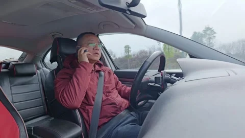 A male driver’s taking a call while driving. Stock Footage 329164162