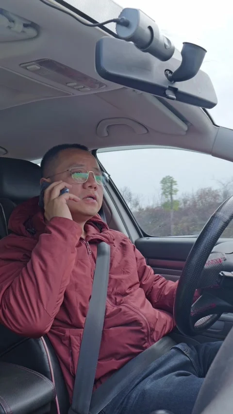 A male driver’s taking a call while driving. Stock Footage 329396891