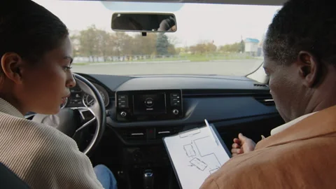 Male Driving Instructor Explaining Parallel Parking to Female Learner Stock Footage 276545053