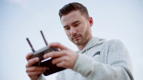 Male drone operator with remote controller flying drone 库存影片 209351448