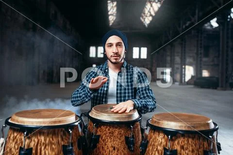 Male drummer plays on wooden drum Stock Photos