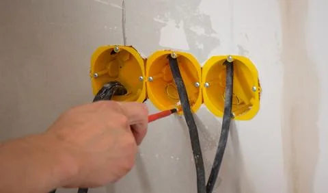 Male electrician installing socket. Selective focus Stock Photos