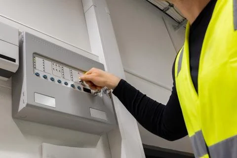 Male Electrician Opening Fire Panel In Server Room Foto stock