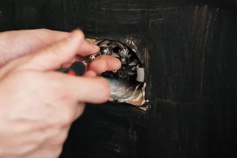 Male electrician repairs an old electrical outlet Stock Photos