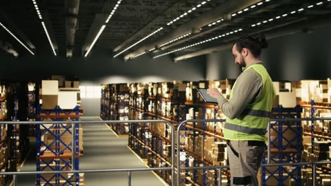 Male employee checking parcel status on a tracking software with tablet Stock Footage 330441198