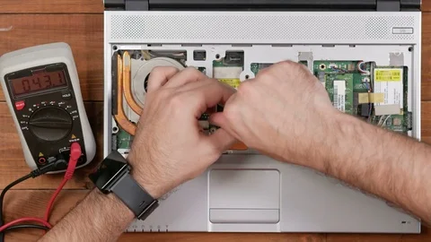 Male engineer assembles the laptop with a screwdriver after repair. Wooden table Stock Footage 72420209