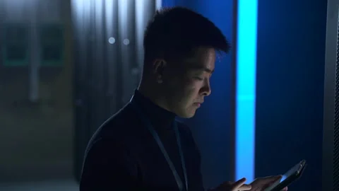 Male engineer checking equipment and typing report on tablet while standing at Stock Footage 163816536