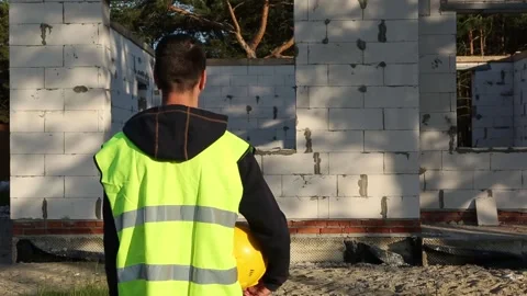 Male engineer at a construction site, standing with his back Stock Footage 156952018