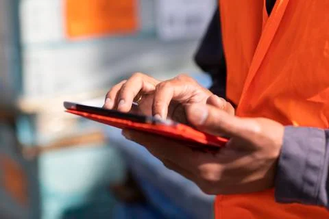 Male engineer on construction site using digital tablet touchscreen, close up of Stock Photos