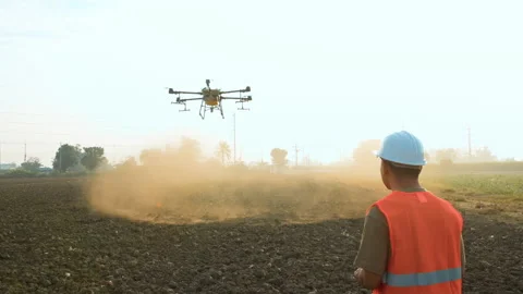 Male engineer controlling drone spraying fertilizer and pesticide over farmla 스톡 동영상 170511050
