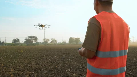 Male engineer controlling drone spraying fertilizer and pesticide over farmla Vídeos de archivo 170511532