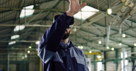 Male engineer having VR headset in a big factory room. Worker in VR glasses Stock Footage 84418191