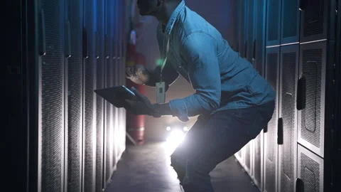 Male engineer inspecting hardware and using device in hands while sitting in big Stock Footage 160806664