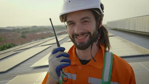 Male engineer looking to camera and smile at solar cell farm. Stock Footage 229155654