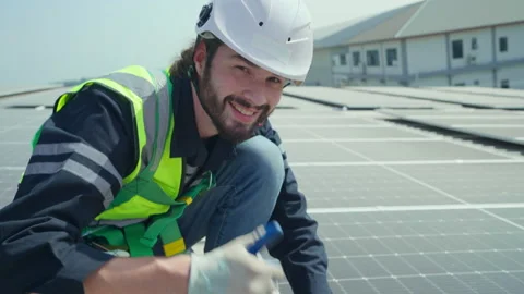 Male engineer looking to camera and smile at solar cell farm. Stock Footage 229361090