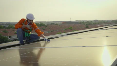 Male engineer maintaining solar cell panels on building rooftop. Video stock 228963176