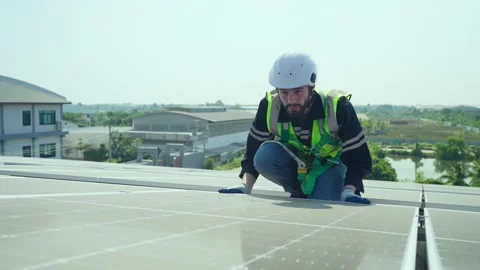 Male engineer maintaining solar cell panels on building rooftop. Stock Footage 229164739