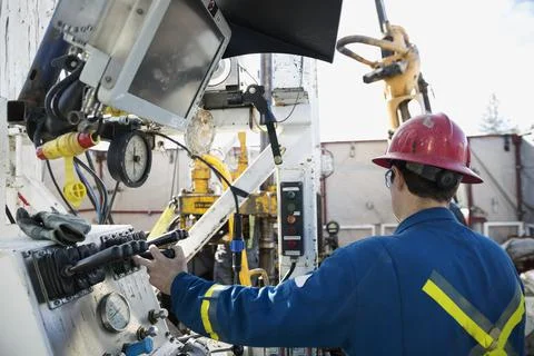 Male engineer operating drilling rig at control panel Stock Photos
