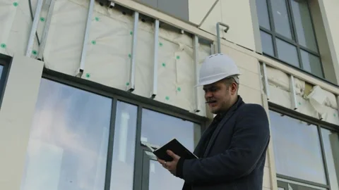 Male engineer or architect looking at a modern building facade and city skyline Stock Footage 323174893