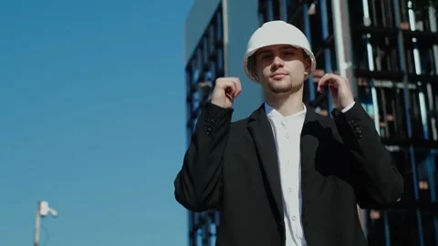 Male engineer or worker in a helmet and vest wearing a white safety helmet and v Stock Footage 249263137
