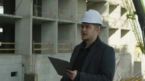 Male engineer pointing out a construction detail on a metal building frame Stock Footage 323166743