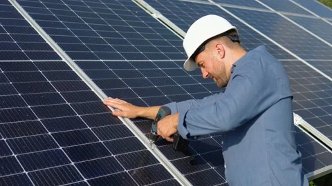 Male engineer in protective helmet installing solar photovoltaic panel system Video stock 205909800