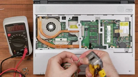 Male engineer to remove the insulation from the wire to repair the laptop Stock Footage 72420149