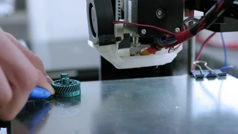 Male engineer removes a plastic object printed on 3D printer from the work desk Stock Footage 132273825