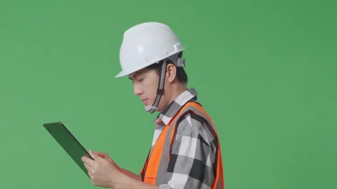 Male Engineer With Safety Helmet Using Tablet While Walking In The Green Screen Stock Footage 247999312