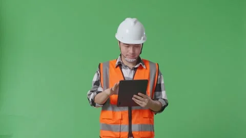 Male Engineer With Safety Helmet Using Tablet While Walking In The Green Screen Stock Footage 248001559