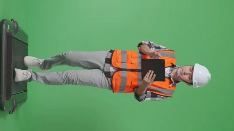 Male Engineer With Safety Helmet Using Tablet While Walking In The Green Screen Stock Footage 248003873