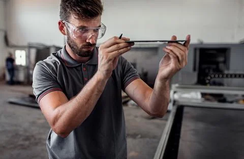 Male engineer setup plasma cutter for work in metalwork workshop. Foto stock