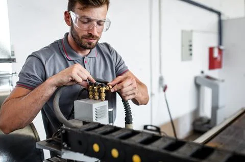 Male engineer setup plasma cutter for work in metalwork workshop. Foto stock