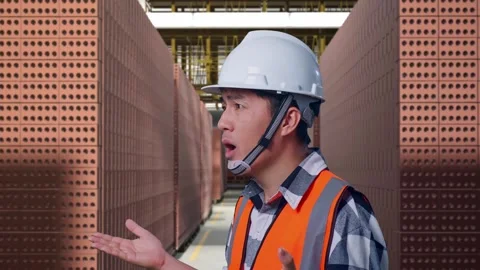 Male Engineer Showing Thumbs Down And Shaking His Head With Brick In Stacks Stock Footage 303760769