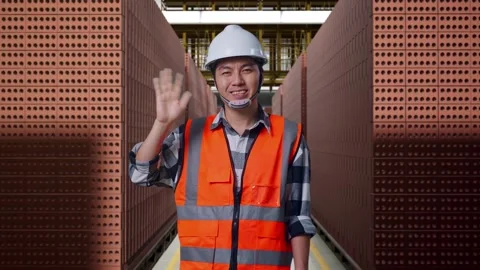 Male Engineer Smiling And Waving Hand Saying Bye With Brick In Stacks Stock Footage 303759545
