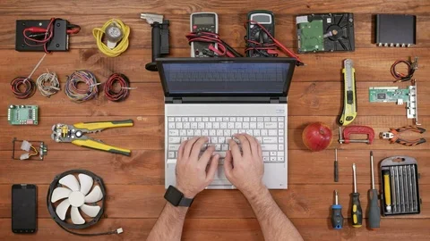 Male engineer software typing at his laptop and eating apple. Wooden table for Stock Footage 72421942